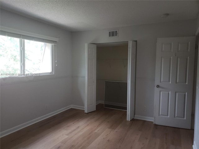 2520 Van Buren St Unit 7, Hollywood, FL 33020 - unfurnished bedroom with light wood finished floors, a closet, a textured ceiling, and baseboards