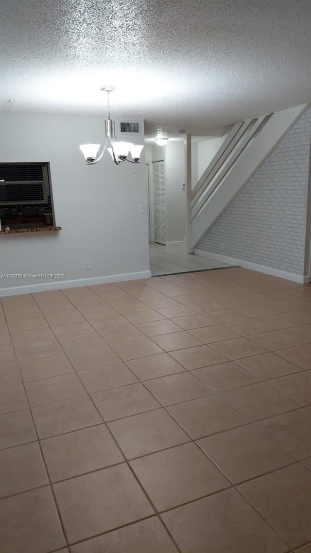 2520 Van Buren St Unit 7, Hollywood, FL 33020 - empty room featuring a chandelier, a textured ceiling, baseboards, stairway, and light tile patterned flooring