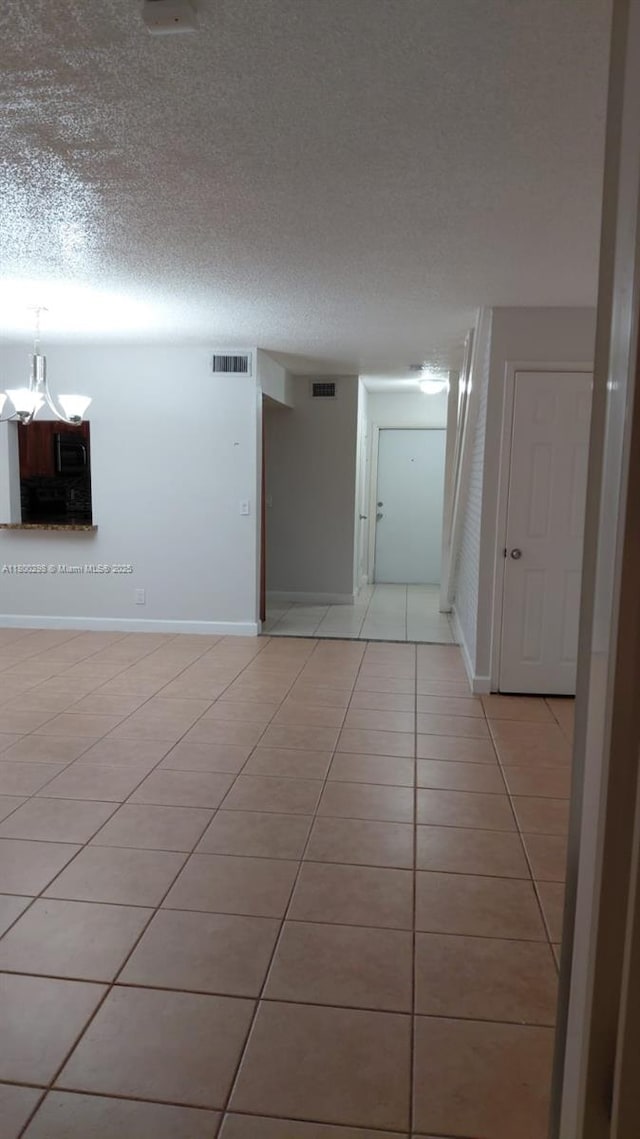 2520 Van Buren St Unit 7, Hollywood, FL 33020 - empty room with light tile patterned floors, baseboards, a chandelier, and a textured ceiling