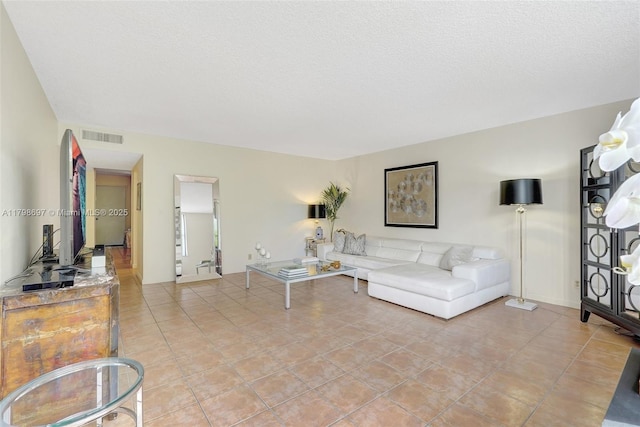living area featuring a textured ceiling and light tile patterned flooring