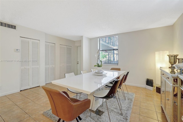dining space featuring light tile patterned flooring and baseboards