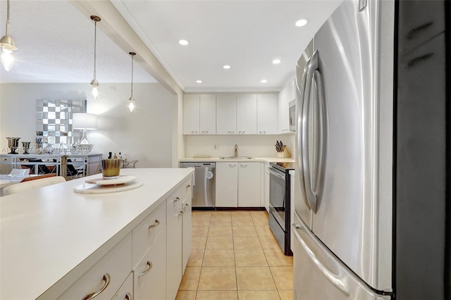 kitchen with appliances with stainless steel finishes, light countertops, light tile patterned flooring, hanging light fixtures, and white cabinets