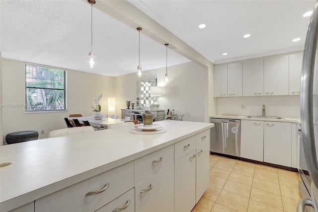 kitchen with stainless steel appliances, a sink, light countertops, decorative light fixtures, and recessed lighting