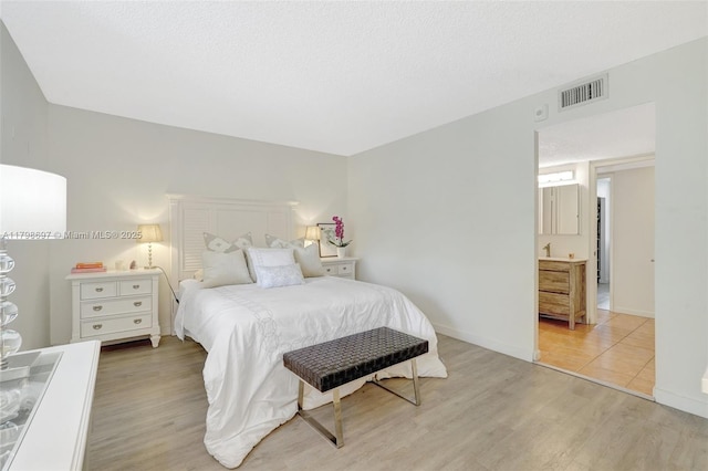 bedroom with light wood finished floors and baseboards