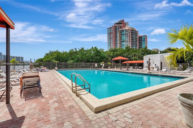 community pool with fence and a patio area
