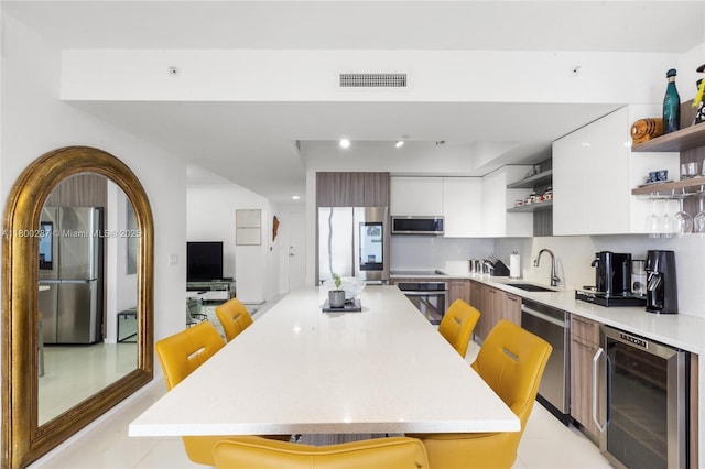 5300 NW 85th Ave Unit 1104, Doral, FL 33166 - kitchen featuring open shelves, appliances with stainless steel finishes, beverage cooler, a sink, and light countertops
