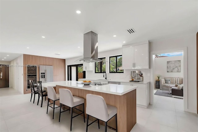 9494 SW 144th St, Miami, FL 33176 - kitchen with island exhaust hood, modern cabinets, a breakfast bar, light countertops, and a center island
