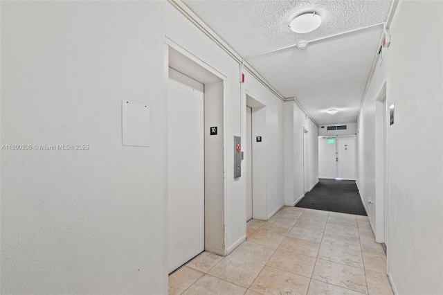 6900 Bay Dr Unit 10I, Miami Beach, FL 33141 - hall featuring elevator, a textured ceiling, light tile patterned floors, and baseboards