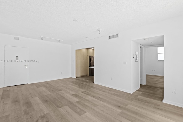 6900 Bay Dr Unit 10I, Miami Beach, FL 33141 - unfurnished room featuring a textured ceiling, light wood-type flooring, and baseboards