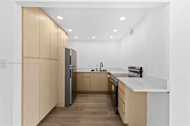 6900 Bay Dr Unit 10I, Miami Beach, FL 33141 - kitchen featuring appliances with stainless steel finishes, light brown cabinetry, a sink, recessed lighting, and light wood finished floors