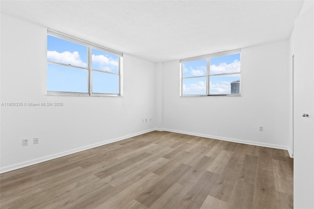 6900 Bay Dr Unit 10I, Miami Beach, FL 33141 - spare room with wood finished floors, healthy amount of natural light, and baseboards