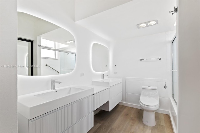 6900 Bay Dr Unit 10I, Miami Beach, FL 33141 - full bathroom with wood finished floors, toilet, double vanity, and shower / bath combination with glass door