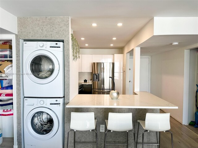 3731 N Country Club Dr Unit 2228, Aventura, FL 33180 - washroom with stacked washer and clothes dryer, wood finished floors, and recessed lighting
