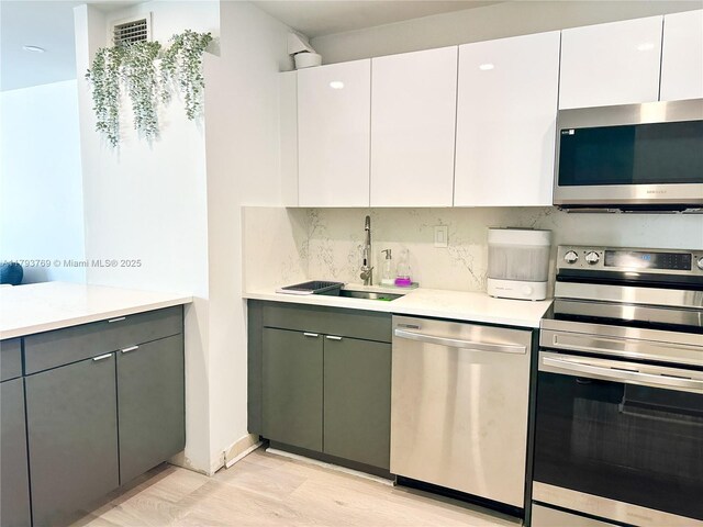 3731 N Country Club Dr Unit 2228, Aventura, FL 33180 - kitchen with appliances with stainless steel finishes, a sink, light wood-style floors, gray cabinets, and light countertops