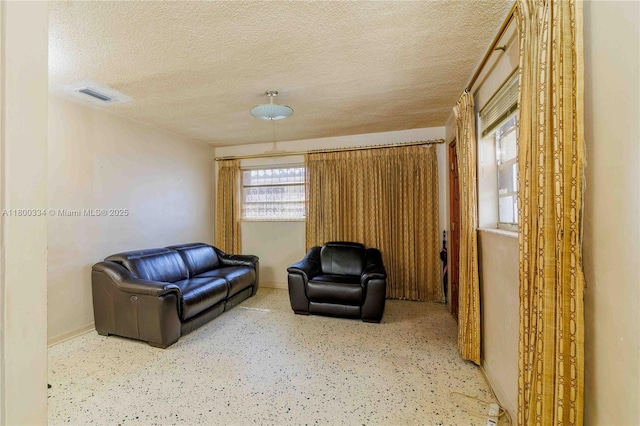 sitting room with a textured ceiling and baseboards