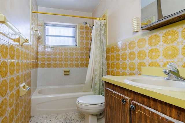 full bath with toilet, shower / bathtub combination with curtain, tile walls, speckle patterned floor, and vanity