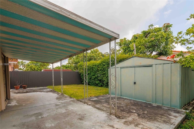 view of patio featuring a storage unit, an outdoor structure, and a carport