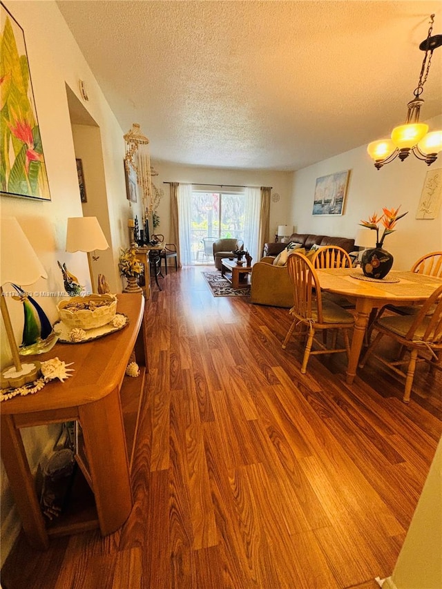 940 Hillcrest Ct Unit 112, Hollywood, FL 33021 - dining area with a textured ceiling, wood finished floors, and a chandelier
