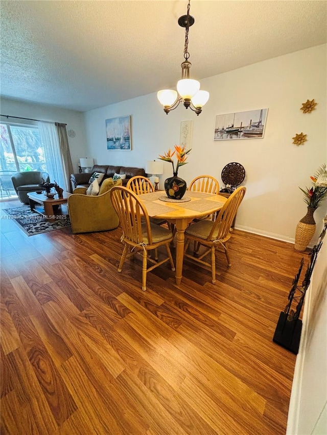 940 Hillcrest Ct Unit 112, Hollywood, FL 33021 - dining space with wood finished floors, a textured ceiling, and a chandelier