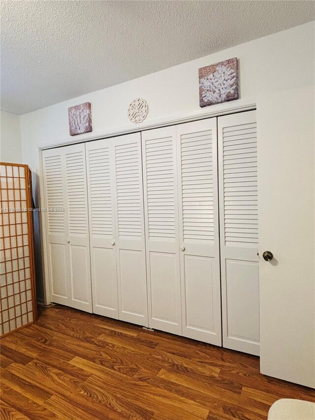 940 Hillcrest Ct Unit 112, Hollywood, FL 33021 - unfurnished bedroom with dark wood-style flooring, a closet, and a textured ceiling