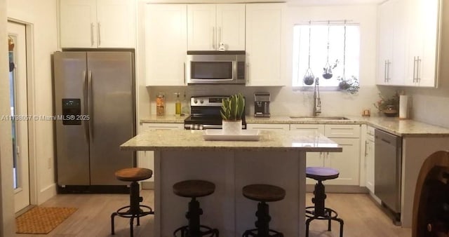 1291 NE 146th St, Miami, FL 33161 - kitchen with stainless steel appliances, white cabinets, and light wood-type flooring