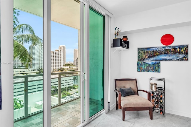 living area with baseboards, a city view, and expansive windows