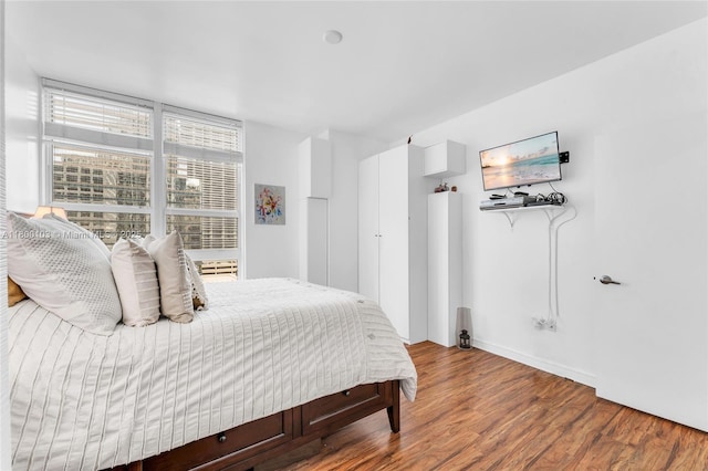 bedroom with wood finished floors and baseboards