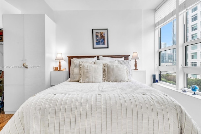 bedroom featuring multiple windows and wood finished floors