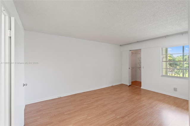 300 SW 134th Way Unit 413E, Pembroke Pines, FL 33027 - unfurnished room featuring light wood-type flooring, a textured ceiling, and baseboards