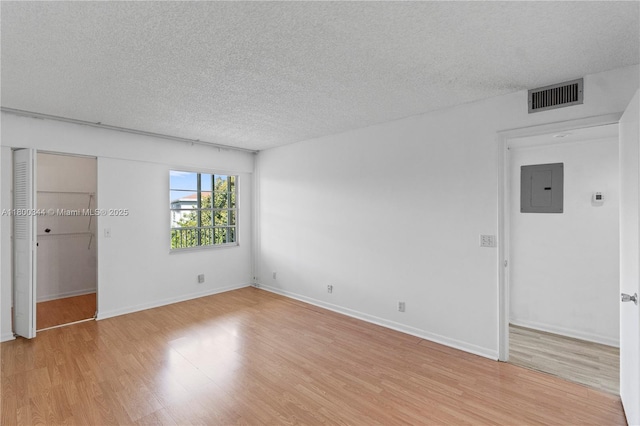 300 SW 134th Way Unit 413E, Pembroke Pines, FL 33027 - unfurnished room featuring electric panel, a textured ceiling, light wood-style flooring, and baseboards