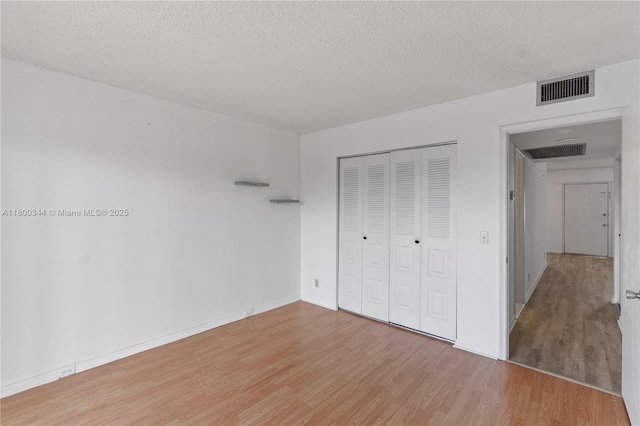 300 SW 134th Way Unit 413E, Pembroke Pines, FL 33027 - unfurnished bedroom featuring light wood finished floors, a closet, a textured ceiling, and baseboards