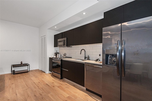 398 NE 5th St Unit 2415, Miami, FL 33132 - kitchen featuring appliances with stainless steel finishes, a sink, dark cabinets, light countertops, and tasteful backsplash