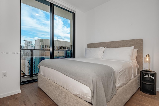 398 NE 5th St Unit 2415, Miami, FL 33132 - bedroom featuring wood finished floors, baseboards, and a city view