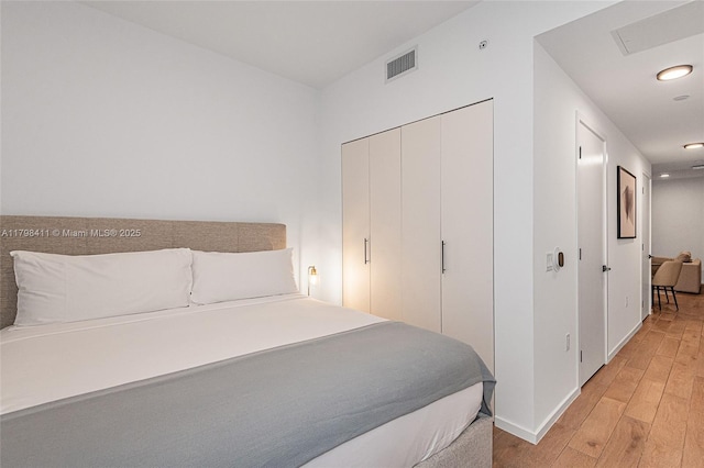398 NE 5th St Unit 2415, Miami, FL 33132 - bedroom with light wood-style flooring, baseboards, recessed lighting, and a closet