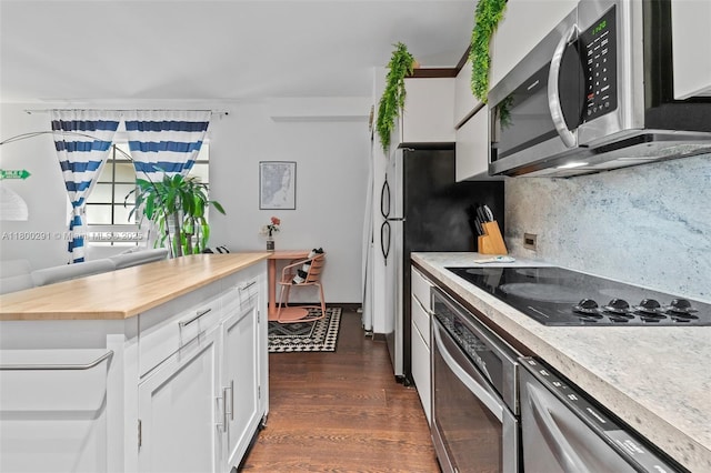 435 21st St Unit 212, Miami Beach, FL 33139 - kitchen featuring stainless steel appliances, butcher block countertops, dark wood-type flooring, white cabinets, and backsplash