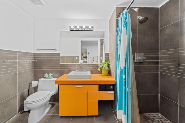 435 21st St Unit 212, Miami Beach, FL 33139 - bathroom featuring a tile shower, tile patterned floors, toilet, vanity, and tile walls