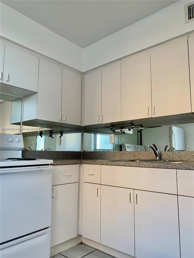 9225 Collins Ave Unit 307, Surfside, FL 33154 - kitchen featuring white range with electric cooktop, white cabinets, and light tile patterned floors