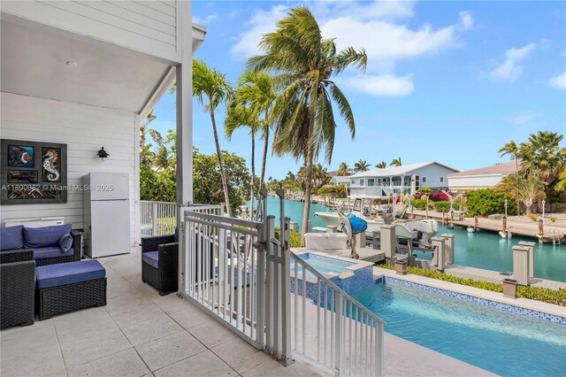 1220 Coury Dr, Key Colony, FL 33051 - view of pool featuring a water view, a boat dock, a pool with connected hot tub, and an outdoor hangout area