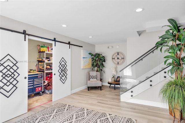 1220 Coury Dr, Key Colony, FL 33051 - sitting room featuring a barn door, wood finished floors, stairway, recessed lighting, and baseboards
