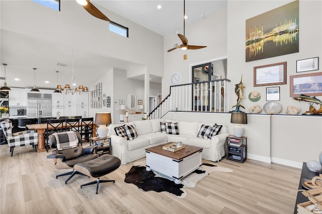 1220 Coury Dr, Key Colony, FL 33051 - living area with ceiling fan, a towering ceiling, light wood-style flooring, stairway, and baseboards