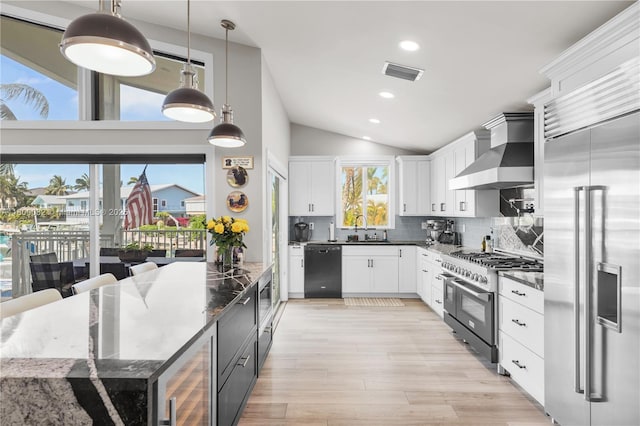 1220 Coury Dr, Key Colony, FL 33051 - kitchen with high quality appliances, wall chimney exhaust hood, vaulted ceiling, a sink, and beverage cooler