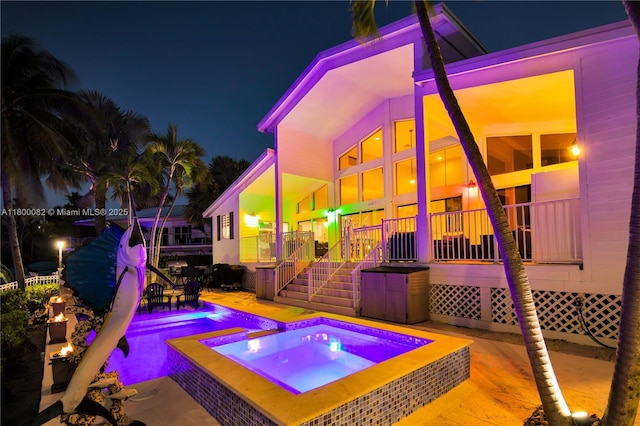 1220 Coury Dr, Key Colony, FL 33051 - patio at night featuring an in-ground hot tub and an outdoor pool
