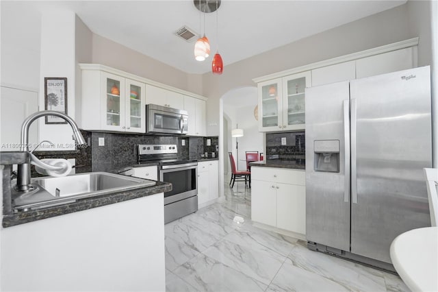 11324 NW 74th Ter, Doral, FL 33178 - kitchen with stainless steel appliances, a sink, dark countertops, light marble finish floors, and arched walkways