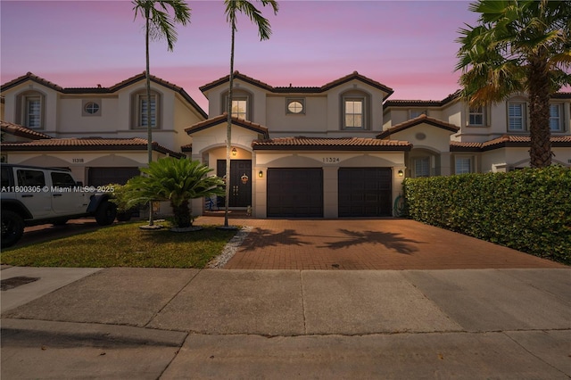 11324 NW 74th Ter, Doral, FL 33178 - mediterranean / spanish-style home featuring decorative driveway, stucco siding, a garage, and a tile roof