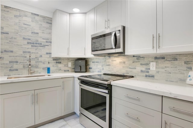 825 Center St Unit 24A, Jupiter, FL 33458 - kitchen featuring stainless steel appliances, a sink, backsplash, and light stone counters