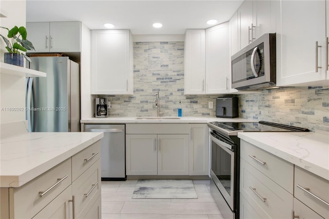 825 Center St Unit 24A, Jupiter, FL 33458 - kitchen with stainless steel appliances, a sink, backsplash, light stone countertops, and recessed lighting