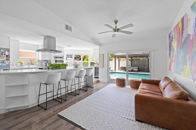 9831 SW 58th Ct, Cooper City, FL 33328 - living room with ceiling fan, wood finished floors, vaulted ceiling, healthy amount of natural light, and a textured ceiling