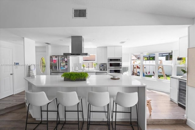 9831 SW 58th Ct, Cooper City, FL 33328 - kitchen with stainless steel appliances, island exhaust hood, wine cooler, modern cabinets, and white cabinets