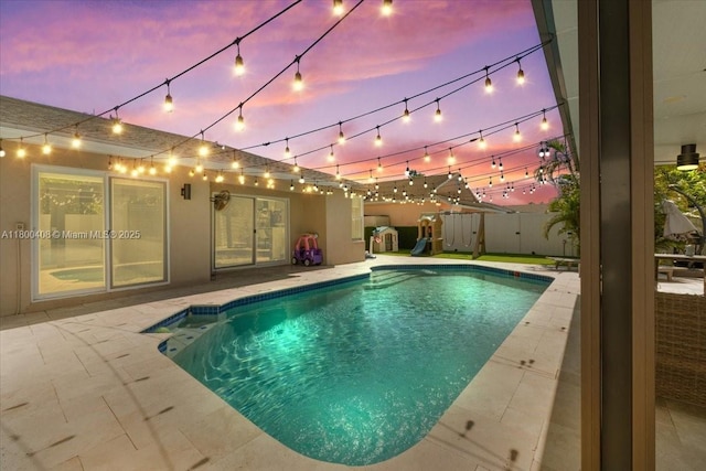 9831 SW 58th Ct, Cooper City, FL 33328 - pool at dusk with a patio and fence