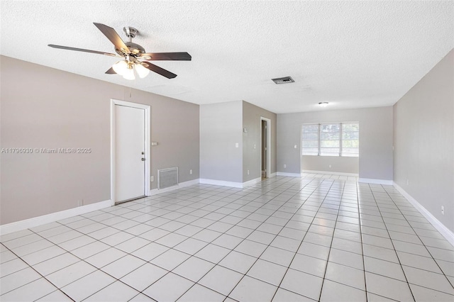 unfurnished room with a textured ceiling, ceiling fan, and baseboards